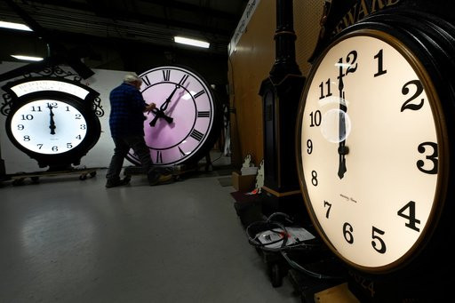 FILE - Clockmaker Scott Gow adjusts the hands of a clock at the Electric Time Company, Oct. 30, 2024, in Medfield, Mass. (AP Photo/Charles Krupa, File)