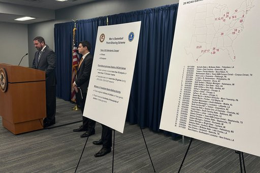 FILE - Information is displayed during a news conference to announce charges against several people including former college basketball players, in what prosecutors called a betting scheme to rig NCAA and Chinese Basketball Association games, Jan. 15, 2026 in Philadelphia. (AP Photo/Tassanee Vejpongsa, File)