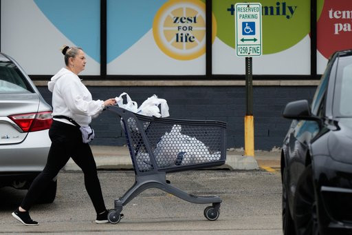 A woman pushes a shopping cart as she leaves a grocery store in Arlington Heights, Ill., Wednesday, Sept. 30, 2026. (AP Photo/Nam Y. Huh)