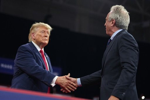 President Donald Trump shakes hands with Health and Human Services Secretary Robert F. Kennedy Jr. at a campaign rally at Alico Arena on the campus of Florida Gulf Coast University, Friday, Oct. 23, 2026, in Fort Myers, Fla. (AP Photo/Mark Schiefelbein)