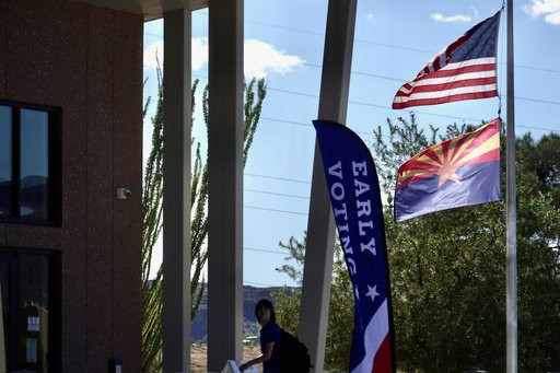 A person walks near an early voting center in Kingman, Ariz., Wednesday, Oct. 7 2026. (AP Photo/Ty ONeil)