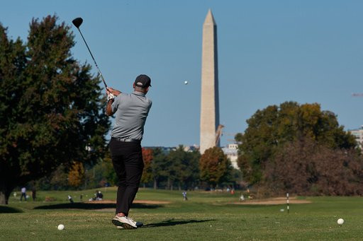 The Washington Monument is seen as a golfer takes a swing at East Potomac Park Golf Course, Monday, Oct. 26, 2026, in Washington. (AP Photo/Julia Demaree Nikhinson)