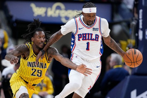 Indiana Pacers guard Quenton Jackson (29) reaches across Philadelphia 76ers guard Kentavious Caldwell-Pope (1) as he goes for the ball during the second half of an NBA basketball game in Indianapolis, Wednesday, Oct. 28, 2026. (AP Photo/Michael Conroy)