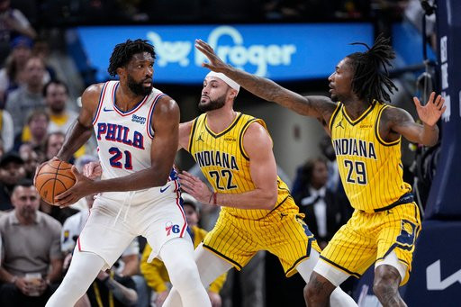 Indiana Pacers guard Quenton Jackson (29) and forward Larry Nance Jr. (22) defend Philadelphia 76ers center Joel Embiid (21) during the first half of an NBA basketball game in Indianapolis, Wednesday, Oct. 28, 2026. (AP Photo/Michael Conroy)