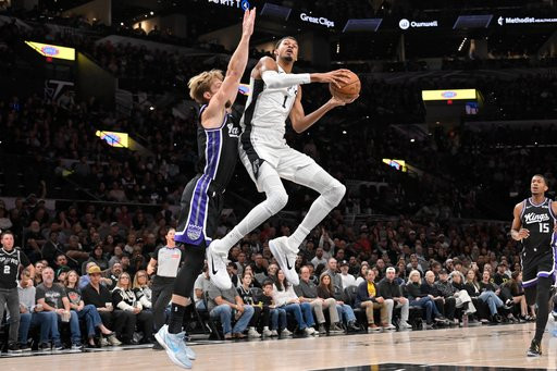San Antonio Spurs center Victor Wembanyama (1) goes to the basket against Sacramento Kings center Domantas Sabonis during the first half of an NBA basketball game, Tuesday, Oct. 27, 2026, in San Antonio. (AP Photo/Darren Abate)
