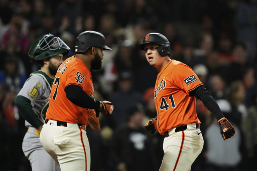 San Francisco Giants' Wilmer Flores, right, celebrates Heliot Ramos after hitting a three-run home run during the sixth inning of a baseball game against the Athletics, Friday, May 16, 2025, in San Francisco. (AP Photo/Godofredo A. Vásquez)