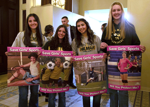 Student athletes hold signs during a hearing to consider bills to pass rules banning transgender student-athletes Tuesday, April 1, 2025, in Sacramento, Calif. (AP Photo/Yuri Avila, File)
