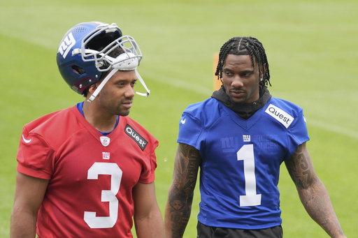 New York Giants' Malik Nabers, right, talks with quarterback Russell Wilson as they walk off the field after NFL football practice in East Rutherford, N.J., Wednesday, May 28, 2025. (AP Photo/Seth Wenig)