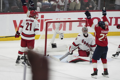 The puck gets past Carolina Hurricanes goaltender Pyotr Kochetkov, center, on a goal scored by Florida Panthers' Aleksander Barkov during the third period in Game 3 of the NHL hockey Stanley Cup Eastern Conference finals Saturday, May 24, 2025, in Sunrise, Fla. (AP Photo/Lynne Sladky)