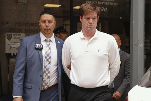 William Duplessie, right, is escorted out of the New York Police 13th Precinct after turning himself in on charges of kidnapping and false imprisonment, Tuesday, May 27, 2025, in New York. (AP Photo/Yuki Iwamura)