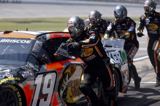 Crew members of Chase Briscoe push his car to get it started after a pit stop during a NASCAR Cup Series auto race at Talladega Superspeedway, Sunday, April 27, 2025, in Talladega, Ala. (AP Photo/Butch Dill)