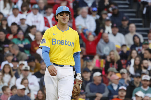 Boston Red Sox third baseman Marcelo Mayer smiles after getting his first out of his career after fielding a ground ball by Baltimore Orioles Ramon Urias in the second inning of the second baseball game of a doubleheader, Saturday, May 24, 2025, at Fenway Park in Boston. (AP Photo/Mary Schwalm)