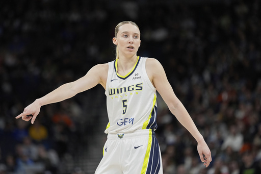 Dallas Wings guard Paige Bueckers (5) points during the first half of a WNBA basketball game against the Minnesota Lynx, Wednesday, May 21, 2025, in Minneapolis. (AP Photo/Abbie Parr)