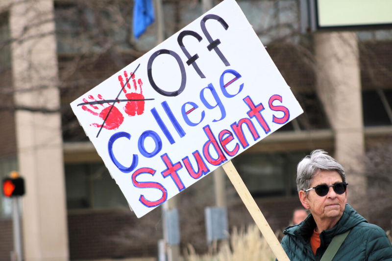 Protestor Pat Braun carries a sign April 23, 2025, in Rapid City, South Dakota, to protest the cancellation of student visas. (Photo by Seth Tupper/South Dakota Searchlight) 