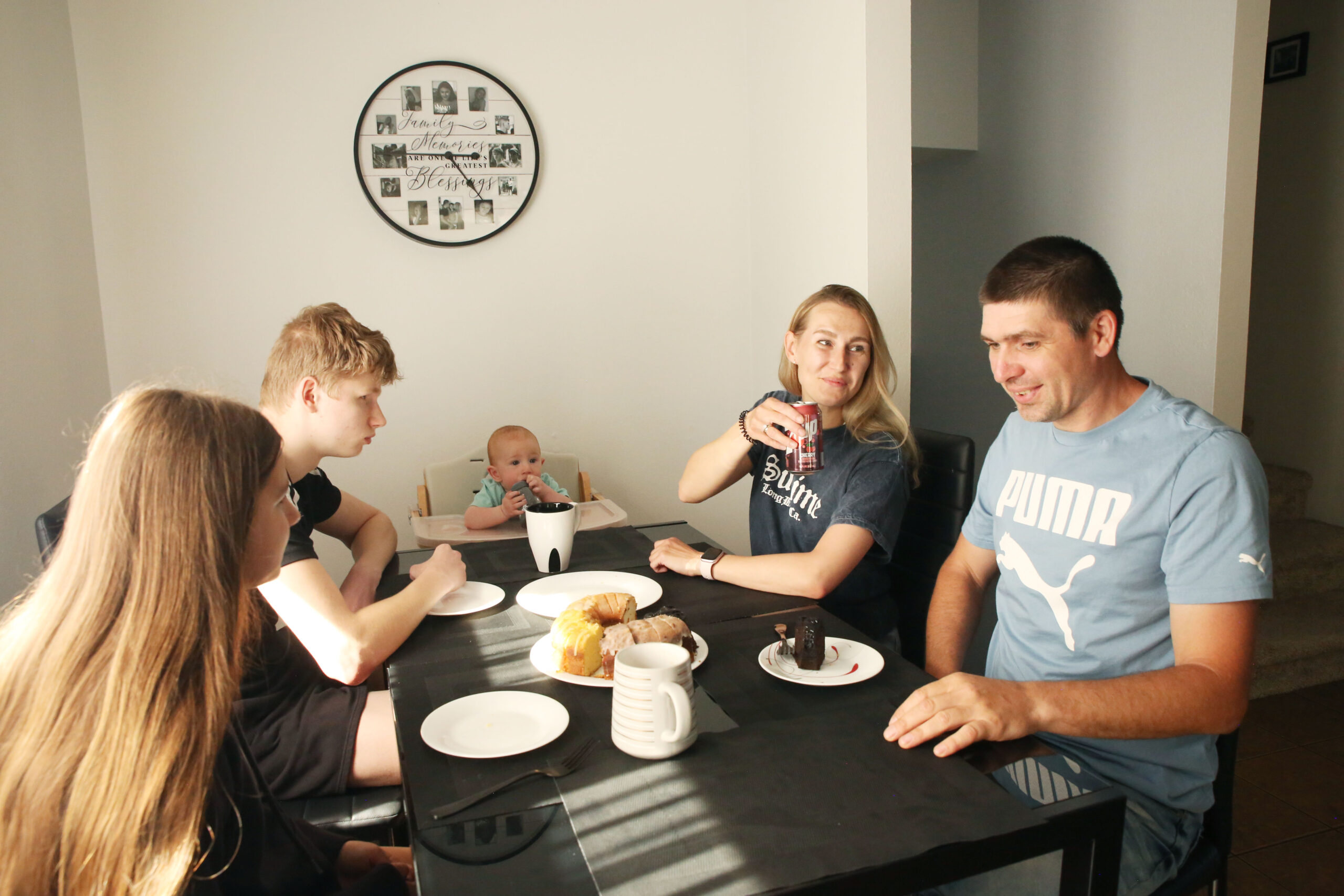 The Biliaze family sit and talk amongst themselves at the kitchen table on May 12, 2025. (Makenzie Huber/South Dakota Searchlight)
