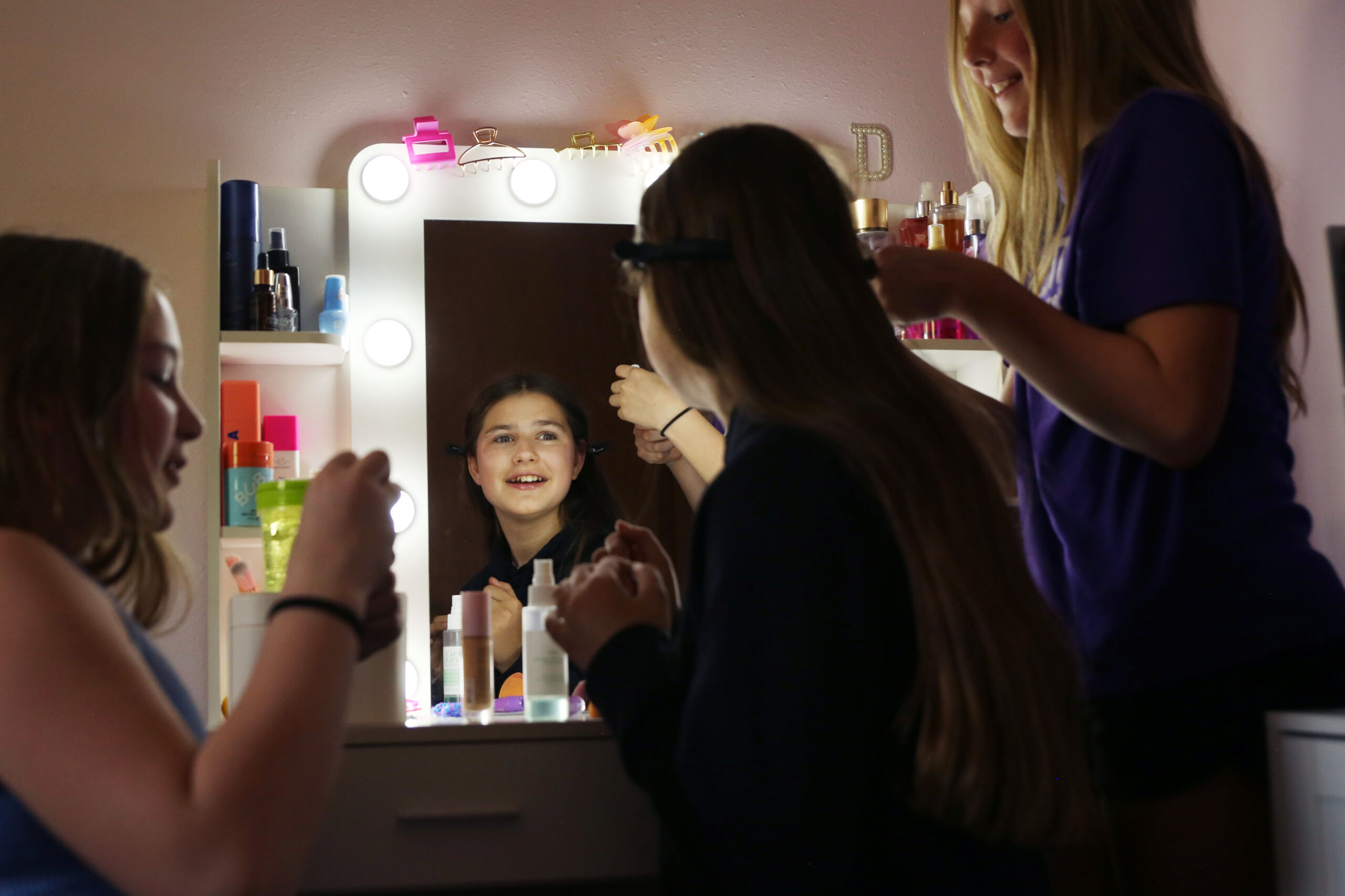 Friends put make up on Dominika Biliaze after school on May 12 in her bedroom in Watertown. (Makenzie Huber/South Dakota Searchlight)