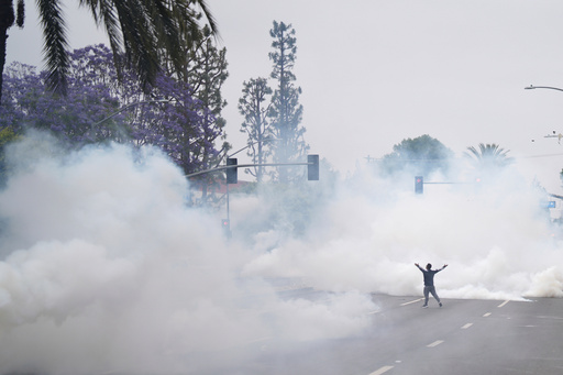Tear gas fills the street as protesters confront Border Patrol personnel during a demonstration over the dozens detained in an operation by federal immigration authorities a day earlier, in Paramount, Calif., on Saturday, June 7, 2025. (AP Photo/Eric Thayer)