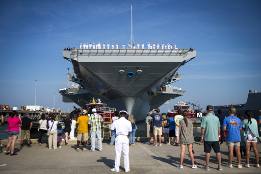 Family and sailors wave as the USS Gerald R. Ford aircraft carrier leaves Naval Station Tuesday, June 24, 2025, in Norfolk, Va. (AP Photo/John Clark)