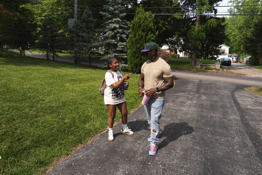 Evan Polk, right, talks with his daughter, Jordyn Polk, 13, after she was dropped off from school in Secane, Pa., Thursday, June 5, 2025. (AP Photo/Matt Slocum)