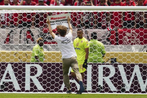 A protester runs on the pitch during the Club World Cup group G soccer match between Manchester City and Wydad AC in Philadelphia, Wednesday, June 18, 2025. (AP Photo/Derik Hamilton)