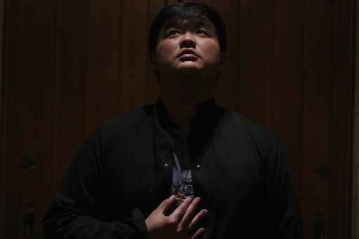 David Kim, a Catholic altar server, stands for a portrait before a Mass at the Princeton University chapel in Princeton, N.J., on Friday, May 16, 2025. (AP Photo/Luis Andres Henao)
