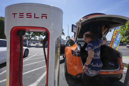 Janelle Lowe prepares to charge her electric vehicle at a charging station Thursday, May 22, 2025, in Long Beach, Calif. (AP Photo/Damian Dovarganes)