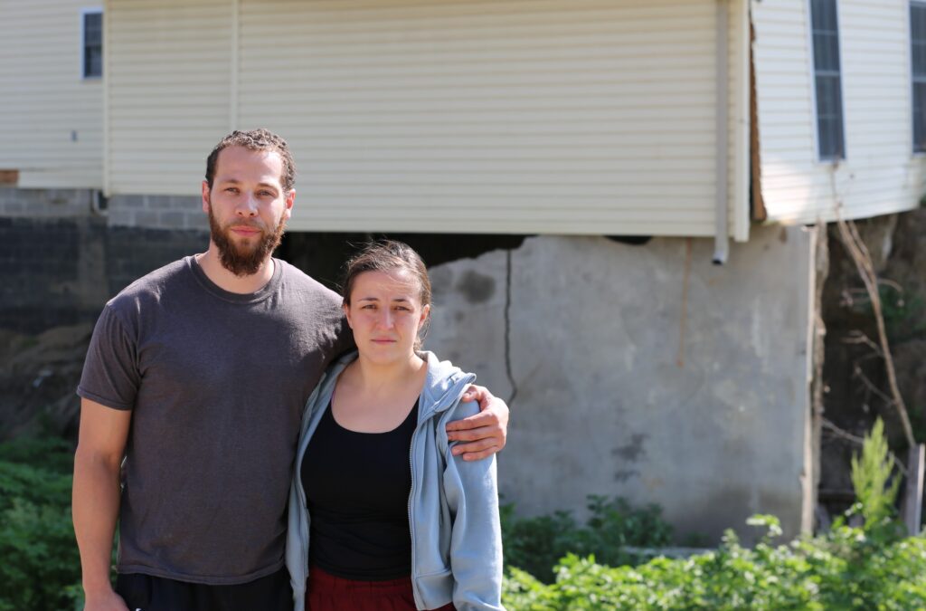 Malcolm and Morgan Speichinger stand in the backyard of their McCook Lake home on June 11, 2025. (Joshua Haiar/South Dakota Searchlight)