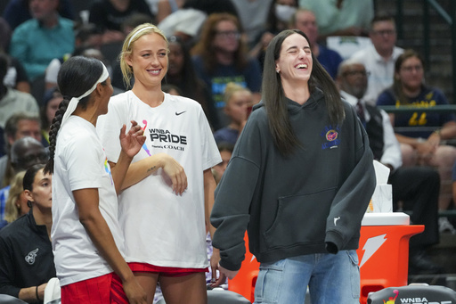 Indiana Fever players, from left, Sydney Colson, Sophie Cunningham and Caitlin Clark react on the bench during the first half of a WNBA basketball game against the Dallas Wings Friday, June 27, 2025, in Dallas. (AP Photo/Julio Cortez)