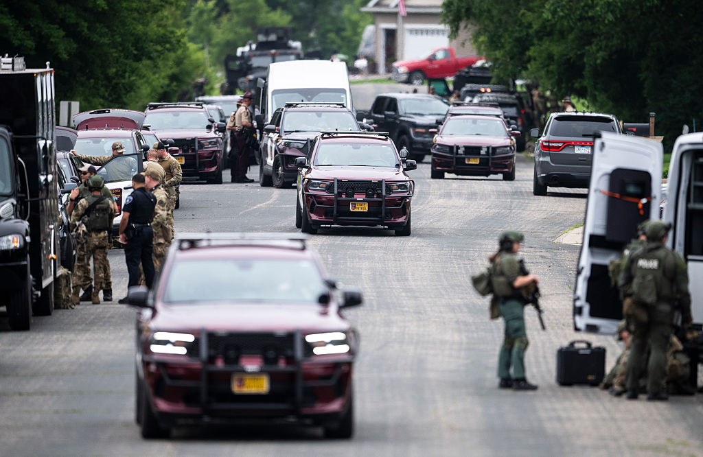 Law enforcement stage in a neighborhood on June 15, 2025, in Green Isle, Minnesota, while searching for a suspect in the killing of DFL State Rep. Melissa Hortman and her husband, Mark Hortman. DFL State Sen. John Hoffman and his wife were also shot and hospitalized. (Stephen Maturen/Getty Images)