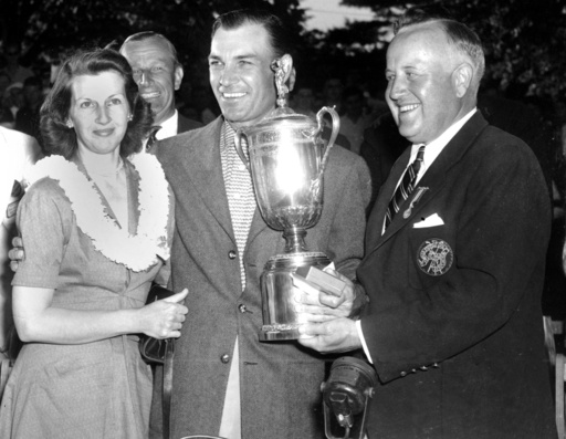 FILE - In this June 11, 1950, file photo, Ben Hogan, center, smiles over a crowd and poses with his wife, Valerie, left, as he receives the U.S. Open Golf Championship trophy from James D. Standish, Jr., Detroit president of the United States Golf Association, in Ardmore, Pa. (AP Photo/File)