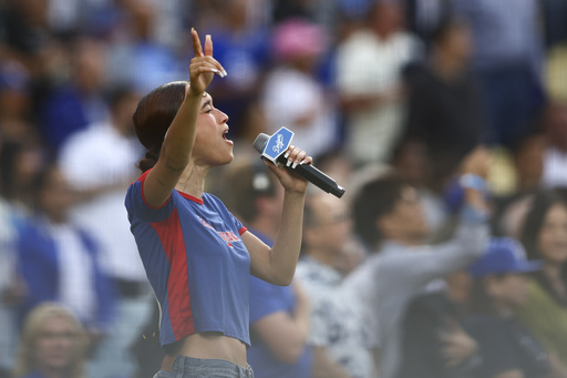 FILE - Music artist Nezza sings the national anthem prior to a baseball game between the Los Angeles Dodgers and the San Francisco Giants in Los Angeles, Saturday, June 14, 2025. (AP Photo/Jessie Alcheh, File)