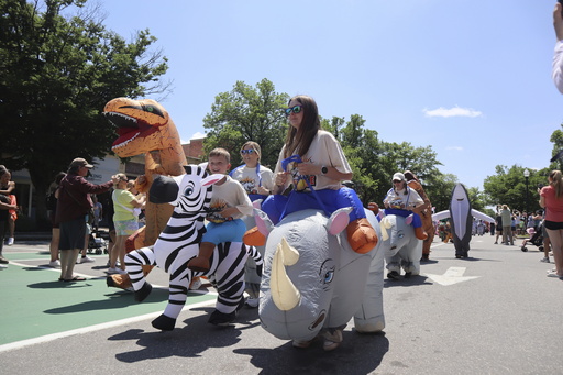 Crowds dressed in inflatable costumes participate in the 'Rhino Rumble Road Race' to celebrate the 30th anniversary of the film 'Jumanji' in downtown Keene, N.H. on Saturday, June 21, 2025. (AP Photo/Leah Willingham)