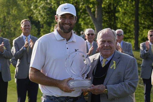 Scottie Scheffler, left, and Jack Nicklaus, right, pose with the trophy after Scheffler won the Memorial golf tournament Sunday, June 1, 2025, in Dublin, Ohio. (AP Photo/Sue Ogrocki)