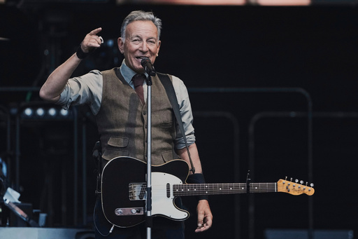 FILE - Bruce Springsteen speaks to the audience during a concert with the E Street Band at the Olympic Stadium in Berlin, Germany, on June 11, 2025. (AP Photo/Markus Schreiber, File)