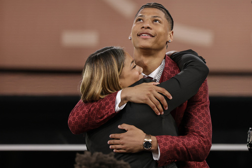 Jeremiah Fears celebrates with family after being selected seventh by the New Orleans Pelicans in the first round of the NBA basketball draft, Wednesday, June 25, 2025, in New York. (AP Photo/Adam Hunger)