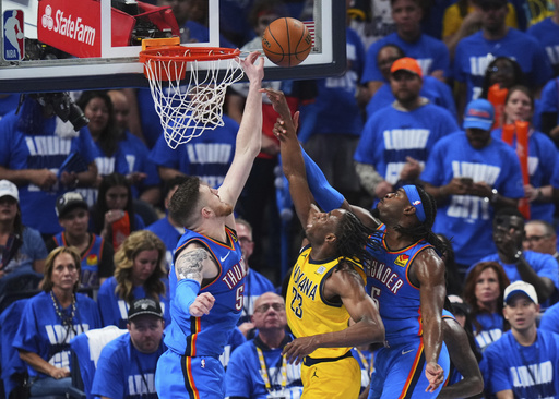 Indiana Pacers forward Aaron Nesmith (23) shoots against Oklahoma City Thunder center Isaiah Hartenstein (55) and guard Luguentz Dort (5) during the second half of Game 2 of the NBA Finals basketball series Sunday, June 8, 2025, in Oklahoma City. (AP Photo/Kyle Phillips)