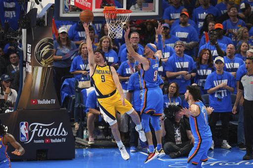 Indiana Pacers guard T.J. McConnell, left, shoots against Oklahoma City Thunder guard Alex Caruso during the second half of Game 2 of the NBA Finals basketball series Sunday, June 8, 2025, in Oklahoma City. (AP Photo/Kyle Phillips)