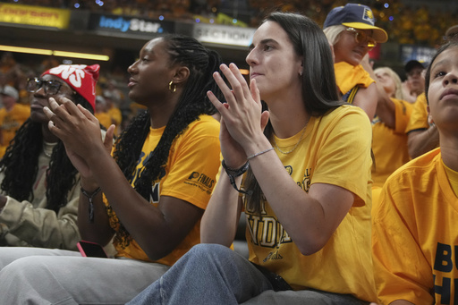 Indian Fever basketball players Caitlin Clark, right, and Aliyah Boston watch during the first half of Game 3 of the NBA Finals basketball series between the Indiana Pacers and the Oklahoma City Thunder, Wednesday, June 11, 2025, in Indianapolis. (AP Photo/Michael Conroy)