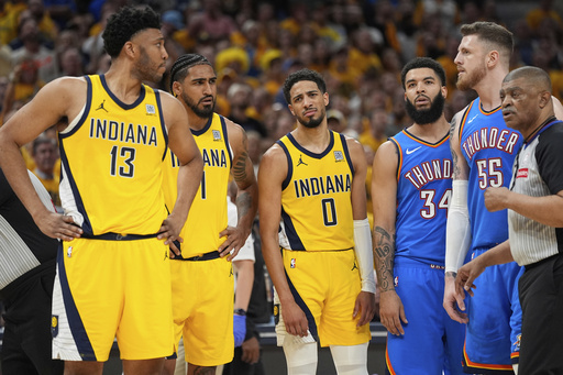 Indiana Pacers center Tony Bradley (13) looks towards Oklahoma City Thunder center Isaiah Hartenstein (55) after a foul as guard Tyrese Haliburton (0) looks toward Bradley during the second half of Game 6 of the NBA Finals basketball series, Thursday, June 19, 2025, in Indianapolis. (AP Photo/Abbie Parr)