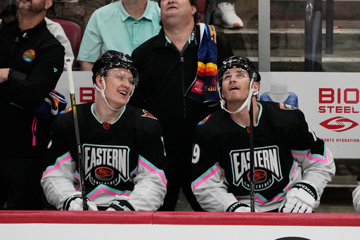 FILE - Atlantic Division's Brady Tkachuk, of the Ottawa Senators (7) and Matthew Tkachuk, of the Florida Panthers (19) watch the rerun of a goal by Matthew assisted by Brady during the NHL All Star hockey game, Feb. 4, 2023, in Sunrise, Fla. (AP Photo/Marta Lavandier, File)