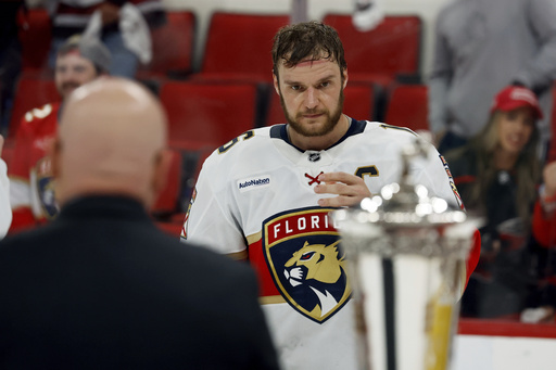 Florida Panthers' Aleksander Barkov (16) skates over to accept the Prince of Wales Trophy following Game 5 of the NHL hockey Stanley Cup Eastern Conference finals against the Carolina Hurricanes in Raleigh, N.C., Wednesday, May 28, 2025. (AP Photo/Karl DeBlaker)
