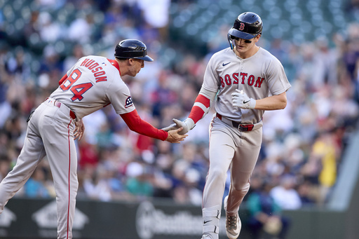 Boston Red Sox's Roman Anthony, right, is greeted by third base coach Kyle Hudson after hitting a solo home run off Seattle Mariners starting pitcher Logan Gilbert during the first inning of a baseball game Monday, June 16, 2025, in Seattle. (AP Photo/John Froschauer)