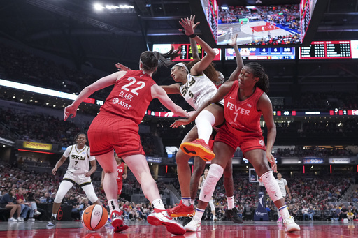 Indiana Fever guard Caitlin Clark, left, battles for the ball with Chicago Sky forward Angel Reese, center, during the second half an WNBA basketball game in Indianapolis, Saturday, May 17, 2025. (AP Photo/AJ Mast)