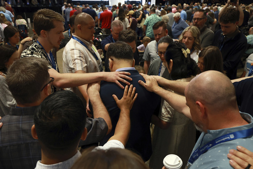 Messengers attending the Southern Baptist Convention lay on hands and pray over missionaries during the 2025 SBC Annual Meeting, Tuesday, June 10, 2025, in Dallas. (AP Photo/Richard W. Rodriguez)