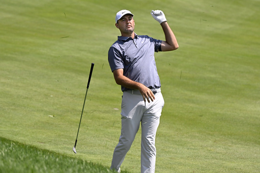 Scottie Scheffler drops his club after hitting his second shot from the rough on the first hole during the second round of the Travelers Championship golf tournament at TPC River Highlands, Friday, June 20, 2025, in Cromwell, Conn. (AP Photo/Jessica Hill)