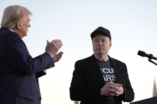 FILE - Republican presidential nominee former President Donald Trump, left, claps as Tesla and SpaceX CEO Elon Musk prepares to depart after a campaign event at the Butler Farm Show on Oct. 5, 2024, in Butler, Pa. (AP Photo/Alex Brandon, File)
