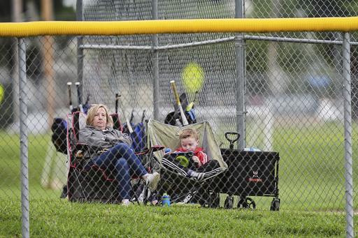 Karli Casamento, watches of her 15-year-old son, Jax's youth baseball game with her son seven-year-old Colt in Aston, Pa., Tuesday, May 27, 2025. (AP Photo/Matt Rourke)