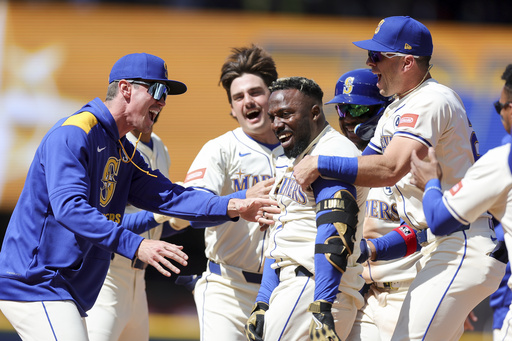 Seattle Mariners' Randy Arozarena, center right, celebrates with teammates after hitting a walkoff single that scored Julio Rodriguez during the ninth inning of a baseball game against the Minnesota Twins, Sunday, Jun 1, 2025, in Seattle. (AP Photo/Ryan Sun)