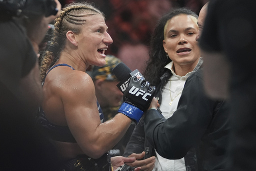 Kayla Harrison, left, talks to Amanda Nunes after her women's bantamweight bout against Julianna Peña at the UFC 316 mixed martial arts event Sunday, June 8, 2025 in Newark, N.J. (AP Photo/Frank Franklin II)