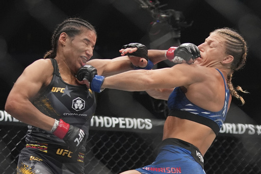Kayla Harrison, right, exchanges punches with Julianna Peña during the second round of a women's bantamweight bout at the UFC 316 mixed martial arts event Sunday, June 8, 2025 in Newark, N.J. (AP Photo/Frank Franklin II)